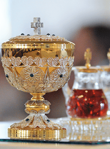 Ornate golden ciborium with chalice and cruets prepared for Catholic Mass