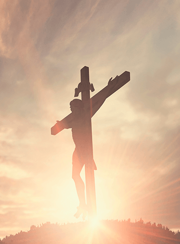 Crucifix of Jesus Christ with radiant sunlight at dawn